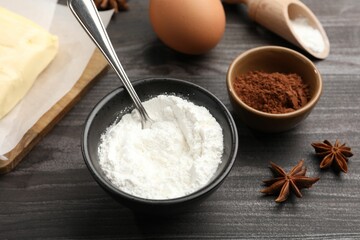 Baking powder, anise stars, egg and cocoa on grey wooden table, closeup