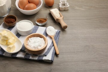 Baking powder in bowl and other products on wooden table. Space for text