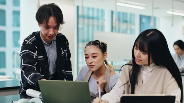 Students, laptop and education teamwork at university with Japanese woman, project and thesis writing. College, class and knowledge with notebook and website research for phd of graduate on app