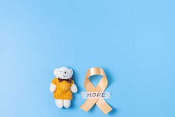 Yellow ribbons with teddy bear toy on a blue background.