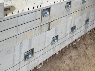 Betonwand mit großen Erdankern