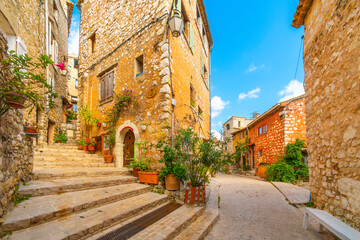 Colorful medieval stone buildings along the Grand Rue main street through the hilltop village of Tourrettes-sur-Loup, France, in the Alpes-Maritimes region of Southern France.	