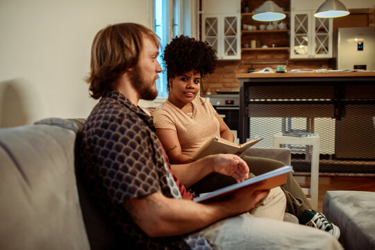 Two friends studying together with books in a cozy kitchen setting