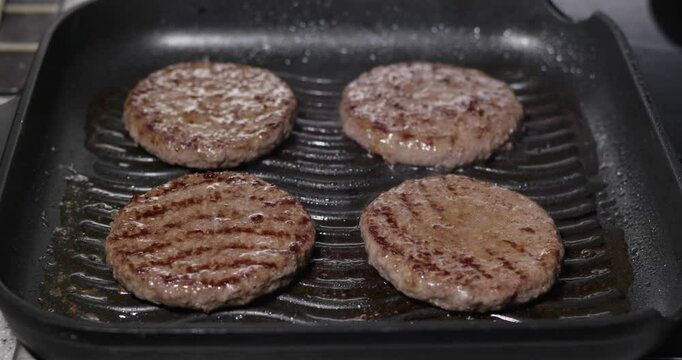 Burger aus saftigem, frischen Rindfleisch werden in einer Grillpfanne gebraten.