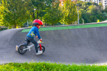 Obraz premium A young boy is riding a bike down a hill