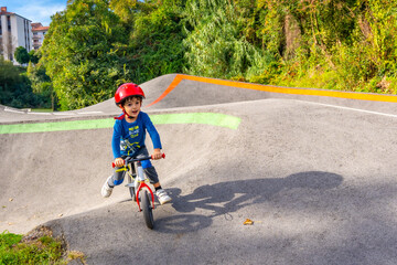 Fototapeta premium A young boy is riding a bike on a dirt road