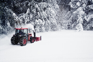 Snow plow tractor blowing snow away.