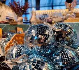 Disco ball colored Christmas baubles are on a store shelf during a Christmas show in a shop and are ready to be sold before the start of the holiday season