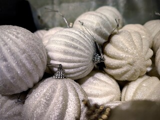 Silver white colored Christmas baubles are on a store shelf during a Christmas show in a shop and are ready to be sold before the start of the holiday season