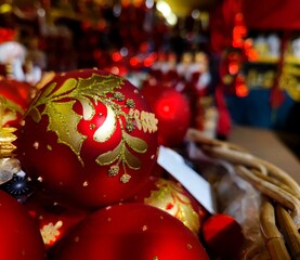 Red gold colored Christmas baubles are on a store shelf during a Christmas show in a shop and are ready to be sold before the start of the holiday season