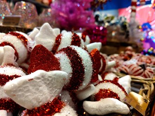 Red white colored candy shaped Christmas baubles are on a store shelf during a Christmas show in a shop and are ready to be sold before the start of the holiday season