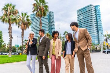 Multi-ethnic colleagues walking along financial district talking relaxed