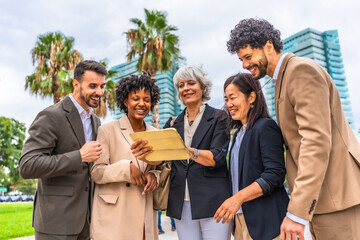 Multi-ethnic colleagues using digital tablet during outdoor business meeting