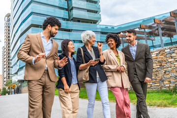 Multi-ethnic business people chatting relaxed walking along financial district