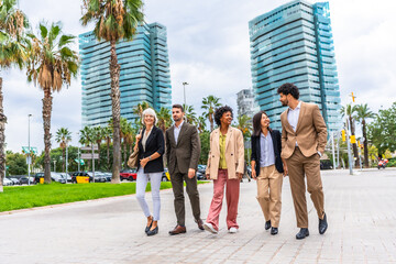 Business people of different ethnicities walking talking along the city