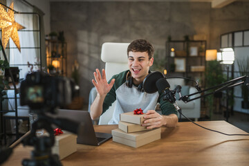 Young adult man share gift boxes during a live video podcast show