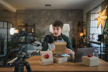 Young adult man influence open gifts while recording a live stream