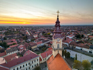 Fototapeta premium European bell tower with old red roof town in the background, Vršac, Serbia - aerial drone photo