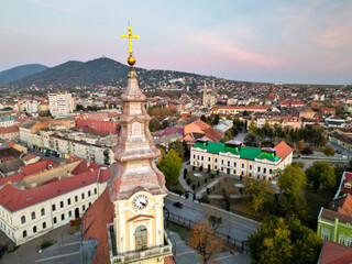 Fototapeta premium European bell tower with old red roof town in the background, Vršac, Serbia - aerial drone photo