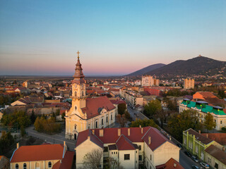 European bell tower with old red roof town in the background, Vršac, Serbia - aerial drone photo