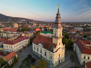 Fototapeta premium European bell tower with old red roof town in the background, Vršac, Serbia - aerial drone photo