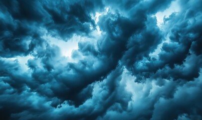 Fototapeta premium Dramatic storm clouds swirling in deep blue hues, showcasing turbulent weather patterns and dynamic formations.