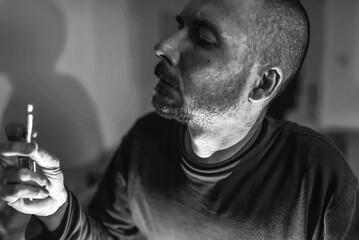Profile of a bearded man smoking a marijuana joint. Close-up 