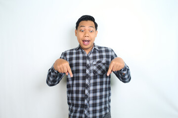 Fototapeta premium surprised and shock asian man pointing hand to copy space wearing casual plaid shirt isolated on white