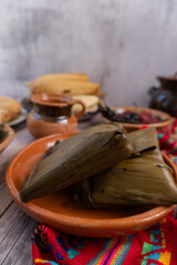 Variedad de tamales, de varios sabores y estilos en mesa, con atole y café platillo mexicano