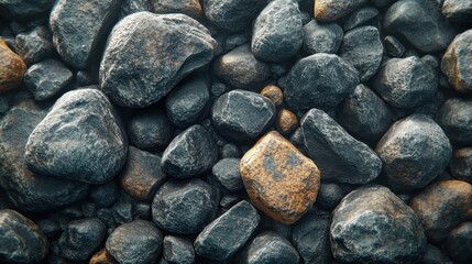 An up-close shot of black rocks and pebbles showing the texture and roughness of the surface.