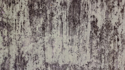 A textured, weathered concrete wall with streaks of dark mold or mildew, creating an abstract, grungy pattern