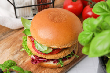Delicious vegan burger with chickpea cutlet on white tiled table, closeup