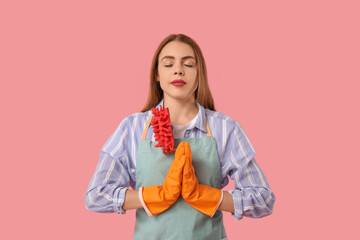 Beautiful young housewife meditating on pink background. Zen concept