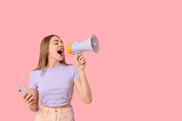 Young beautiful woman with mobile phone and megaphone on pink background