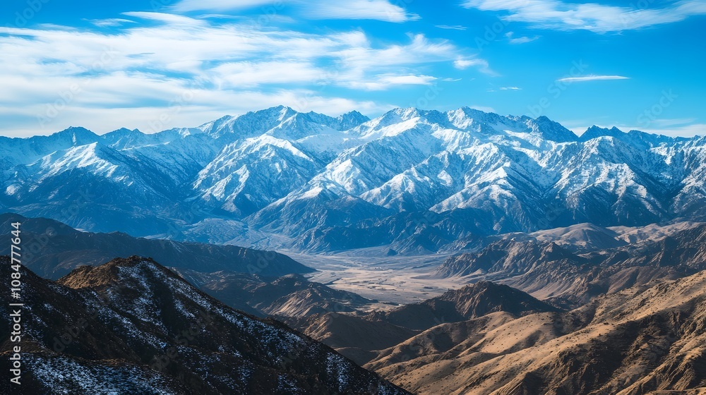 Leinwandbilder Expansive view of a snowy mountain range, with peaks and valleys creating a symmetrical pattern of light and shadow across the rugged terrain.