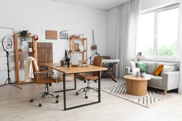 Interior of podcaster's studio with workplace, sofa and shelf units