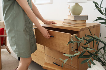 Woman opening drawer at home, closeup