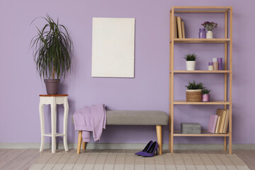 Comfortable bench, shelving unit, picture and table in stylish interior of living room