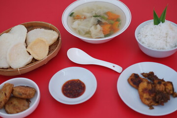 traditional Indonesian food arranged neatly on a red surface