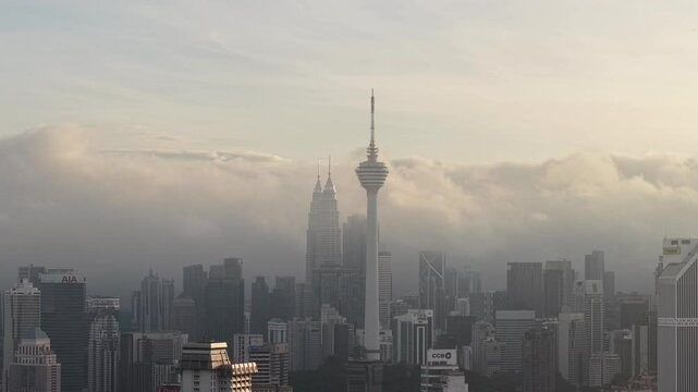 dramatic sunrise with low cloud above Kuala Lumpur city center visible sky scraper tower above the cloud