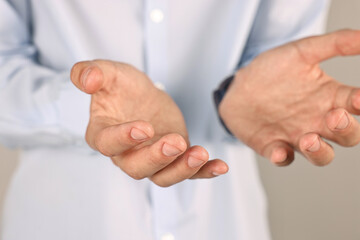 Man holding something on grey background, closeup