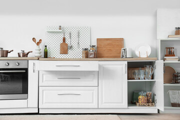 Interior of kitchen with open drawers, pegboard and utensils