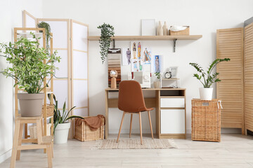 Interior of atelier with tailor's workplace, shelf and folding screens