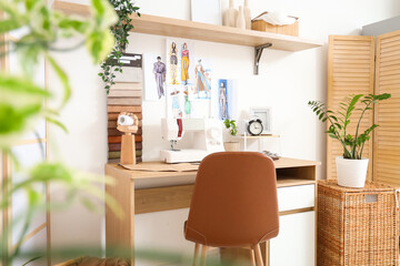 Interior of atelier with tailor's workplace, drawings and shelf