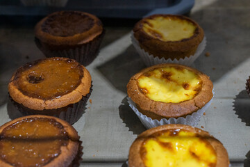 the irresistible allure of freshly baked egg tarts, their golden, flaky crusts perfectly crisp and their creamy custard filling gleaming under the light.