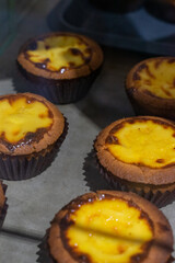 the irresistible allure of freshly baked egg tarts, their golden, flaky crusts perfectly crisp and their creamy custard filling gleaming under the light.