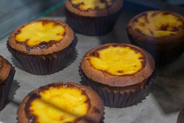 the irresistible allure of freshly baked egg tarts, their golden, flaky crusts perfectly crisp and their creamy custard filling gleaming under the light.