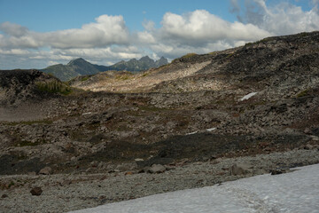 Trail Crosses Snow Field Toward Rocky Hills Of Spray Park