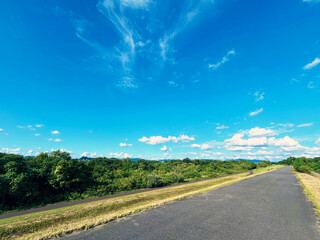 堤防のサイクリングロードと青空