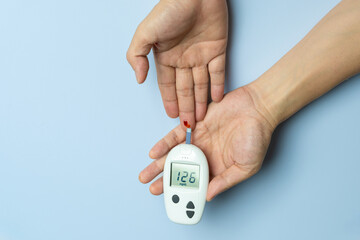hand of woman check diabetes and high blood glucose monitor with digital pressure gauge. Healthcare and Medical concept	